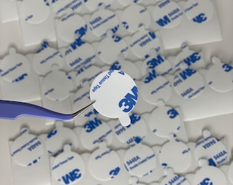 Könnte beinhalten: Nahaufnahme eines Stapels weißer, runder, selbstklebender Aufkleber mit einem blauen 3M-Logo und dem Text "9448A Double Coated Tissue Tape".