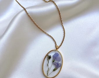 Colgante de acero inoxidable dorado con flor silvestre azul real en resina