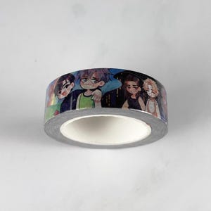 Può includere: Rotolo di nastro washi decorativo con un motivo ripetuto di personaggi in stile anime. Il nastro ha un bordo argentato e un interno bianco. I personaggi sono raffigurati in vari abiti e pose, con uno sfondo colorato.