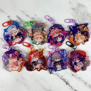 May include: Ten colourful keychains featuring anime characters with different coloured backgrounds. Each keychain has a different character with a unique design and colour scheme.