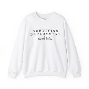 May include: White long-sleeve sweatshirt with the text "SURVIVING DEPLOYMENT (with kids)" printed in black.