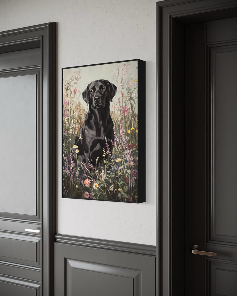 Pode incluir: Um c&atilde;o Labrador Retriever preto sentado em um campo de flores silvestres. O c&atilde;o est&aacute; olhando diretamente para a c&acirc;mera. As flores s&atilde;o rosa, roxo e branco.