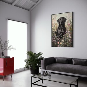 Pode incluir: Um c&atilde;o Labrador Retriever preto sentado em um campo de flores silvestres. O c&atilde;o est&aacute; olhando diretamente para a c&acirc;mera. O fundo &eacute; uma imagem desfocada de flores silvestres.