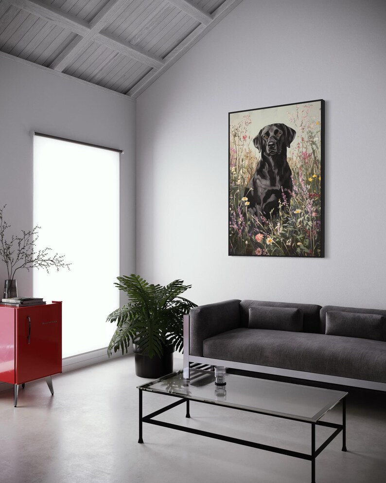 Pode incluir: Um c&atilde;o Labrador Retriever preto sentado em um campo de flores silvestres. O c&atilde;o est&aacute; olhando diretamente para a c&acirc;mera. O fundo &eacute; uma imagem desfocada de flores silvestres.
