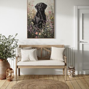 Pode incluir: Um c&atilde;o labrador retriever preto est&aacute; sentado em um campo de flores silvestres. O c&atilde;o est&aacute; olhando diretamente para a c&acirc;mera. O fundo &eacute; um campo de flores silvestres em tons de rosa, roxo, amarelo e branco.