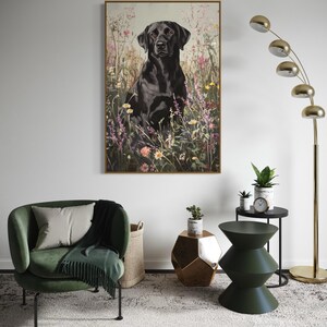 Pode incluir: Um c&atilde;o Labrador Retriever preto sentado em um campo de flores silvestres. O c&atilde;o est&aacute; olhando diretamente para a c&acirc;mera. O fundo &eacute; uma imagem suave e desfocada das flores.