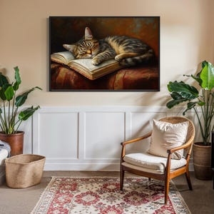This heartwarming art print captures a peaceful kitten sleeping on an open book. The soft lighting and cozy atmosphere make this piece perfect for book lovers and cat enthusiasts alike. The detailed brushstrokes highlight the kitten’s fluffy fur, creating a charming and serene scene. Whether for a reading nook, bedroom, or study, this print adds warmth and relaxation to any space. A perfect gift for literature lovers, pet owners, or anyone who appreciates quiet, dreamy moments.