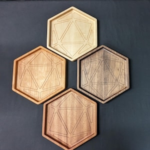 May include: Four wooden hexagon-shaped trays with a geometric design. The trays are in various shades of wood, including light, medium, and dark tones. The design is a carved, three-dimensional pattern.