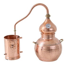 Traditionell koppardestillator för utvinning av eteriska oljor och hydrosoler. Destillering av aromatiska växter... sprit...