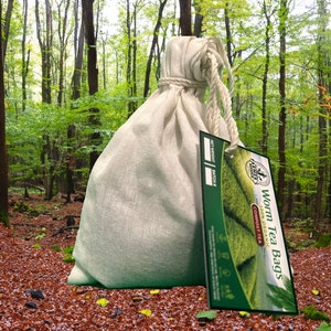 May include: A white cloth bag filled with compost tea bags. The bag is tied with a white rope and has a green label that says "Worm Tea Bags Compost Tea 100% Organic".