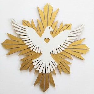 Puede incluir: Una paloma de madera blanca con un recorte en forma de corazón, colocada sobre un diseño de rayos dorados. La paloma tiene las alas extendidas. Esta decoración de pared es ideal para la decoración de interiores.