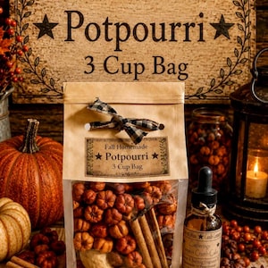 May include: A clear plastic bag filled with dried orange pumpkin-shaped potpourri and cinnamon sticks, tied with a black and white checkered ribbon. The label reads Fall Homemade Potpourri 3 Cup Bag. A brown glass dropper bottle sits beside it.