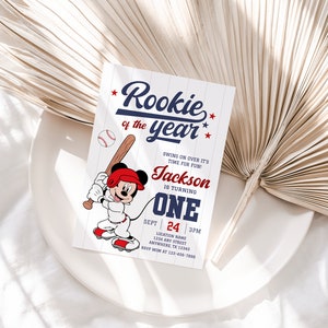 May include: A baseball-themed birthday invitation with a cartoon Mickey Mouse character holding a bat. The invitation says "Rookie of the year" and includes the name "Jackson" and the age "One".
