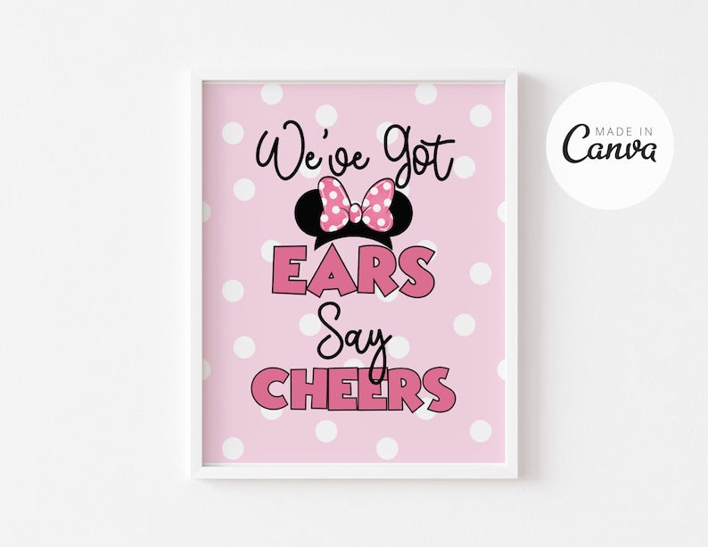 May include: Pink printable sign with white polka dots featuring a black and white silhouette of Minnie Mouse ears with a pink bow. The text reads "We've got ears say CHEERS".