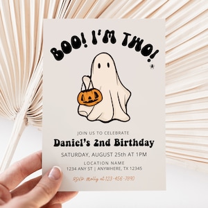 May include: A white ghost with a black outline holding a jack-o-lantern. The text "BOO! I'M TWO!" is in black with a white outline. The invitation is for Daniel's 2nd birthday on August 25th at 1 PM. The location is 1234 Any St, Anywhere, TX 12345. RSVP to Molly at 123-456-7890.