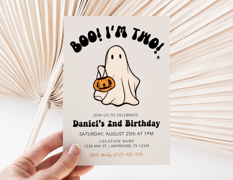 May include: A white ghost with a black outline holding a jack-o-lantern. The text "BOO! I'M TWO!" is in black with a white outline. The invitation is for Daniel's 2nd birthday on August 25th at 1 PM. The location is 1234 Any St, Anywhere, TX 12345. RSVP to Molly at 123-456-7890.