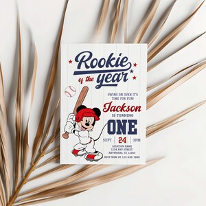 May include: A baseball-themed birthday invitation with a cartoon Mickey Mouse character holding a bat. The invitation reads "Rookie of the year" and includes the name "Jackson" and the age "One".
