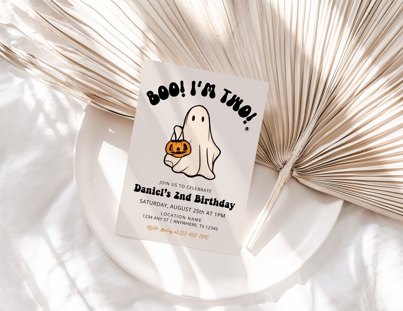 May include: A white card with a cartoon ghost holding a pumpkin bucket. The card says "BOO! I'M TWO!" and has the text "Join us to celebrate Daniel's 2nd Birthday" with details for the event.
