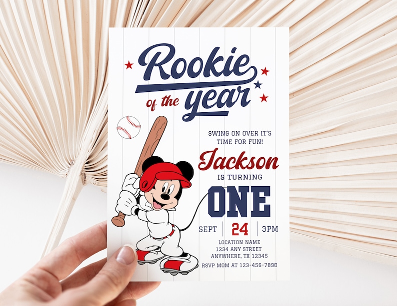 May include: A baseball-themed birthday invitation with a cartoon Mickey Mouse character wearing a baseball uniform and holding a bat. The invitation says "Rookie of the year" and "Jackson is turning one".