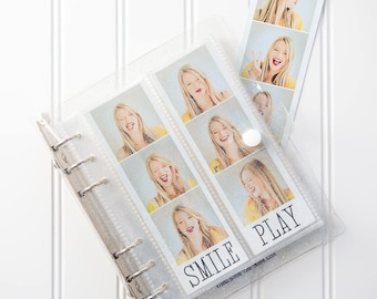Puede incluir: Un álbum de fotos transparente y brillante con una encuadernación plateada. El álbum contiene varias tiras estilo fotomatón con imágenes de una persona sonriente. Las palabras "SMILE" y "PLAY" están impresas en las fotos.