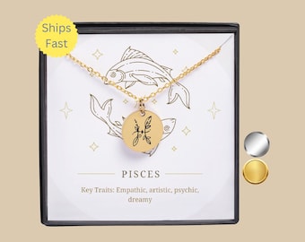 May include: Gold necklace with a Pisces zodiac sign pendant in a black gift box. The pendant features a stylised image of two fish with a floral design. The box has a white background with the words "Pisces" and "Key Traits: Empathic, artistic, psychic, dreamy".
