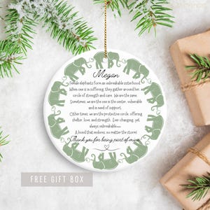 Peut inclure: Ornement rond blanc avec un motif d'&eacute;l&eacute;phant vert et le texte "Les &eacute;l&eacute;phantes femelles forment une sororit&eacute; incassable. Lorsqu'une est en souffrance, elles se rassemblent autour d'elle. Un cercle de force et de soins. Nous sommes les m&ecirc;mes. Parfois, nous sommes celle qui est au centre, vuln&eacute;rable et a besoin de soutien. D'autres fois, nous sommes le cercle protecteur, offrant abri, amour et force. En constante &eacute;volution, mais toujours incassable - Un lien qui dure, quoi qu'il arrive ! Merci d'&ecirc;tre une partie de moi !"