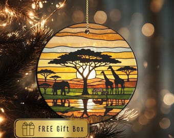 May include: Round Christmas ornament with a safari scene. The ornament features a sunset with a silhouette of a tree, giraffes, an elephant, and zebras. The text "TheCustomPendant" is at the top. The words "FREE Gift Box" are at the bottom.