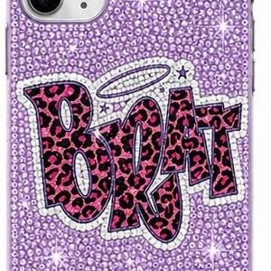 Puede incluir: Una funda de teléfono morada cubierta totalmente por pequeños brillantes centelleantes. En el centro aparece la palabra BRAT en letras grandes con estampado de leopardo rosa y negro, delineadas con brillantes blancos y un halo sobre la R.