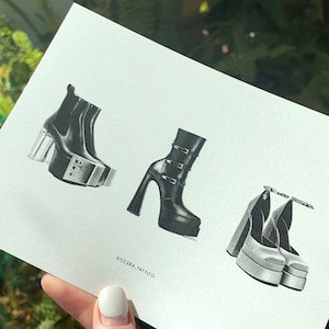May include: Black and white illustration of three pairs of platform shoes. The drawing includes a pair of ankle boots with clear heels, a pair of high-heeled boots with multiple buckles, and a pair of platform heels with chain details. The text "VISCERA. TATTOO" is at the bottom.