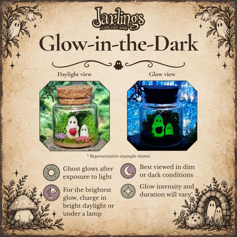 May include: A Jarlings Little Lost Souls glow-in-the-dark glass jar containing two small white ghost figurines, one holding a red apple, set in green moss. The display shows a daylight view and a glow view, with text explaining the glow effect.