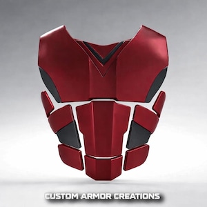 Puede incluir: Una pieza de armadura segmentada para el pecho y el abdomen con un acabado rojo metálico y detalles en negro mate. El diseño consta de una placa pectoral grande, una sección abdominal central y paneles laterales. El texto CUSTOM ARMOR CREATIONS es visible en la parte inferior.