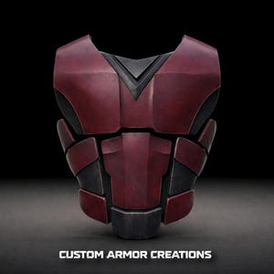 May include: A burgundy and black chest armor piece with a geometric design. The armor is made of multiple panels and features the text "CUSTOM ARMOR CREATIONS" at the bottom. The armor is designed for protection and cosplay.