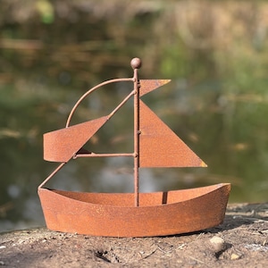 May include: A rusty metal sailboat sculpture with a small, rounded hull and a single sail. The sculpture is weathered and has a rustic appearance.