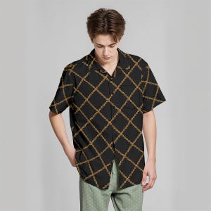 May include: Black short-sleeve shirt with a gold chain pattern. The shirt has a classic collar and a single pocket on the chest. The chain design is arranged in a diamond grid across the shirt.