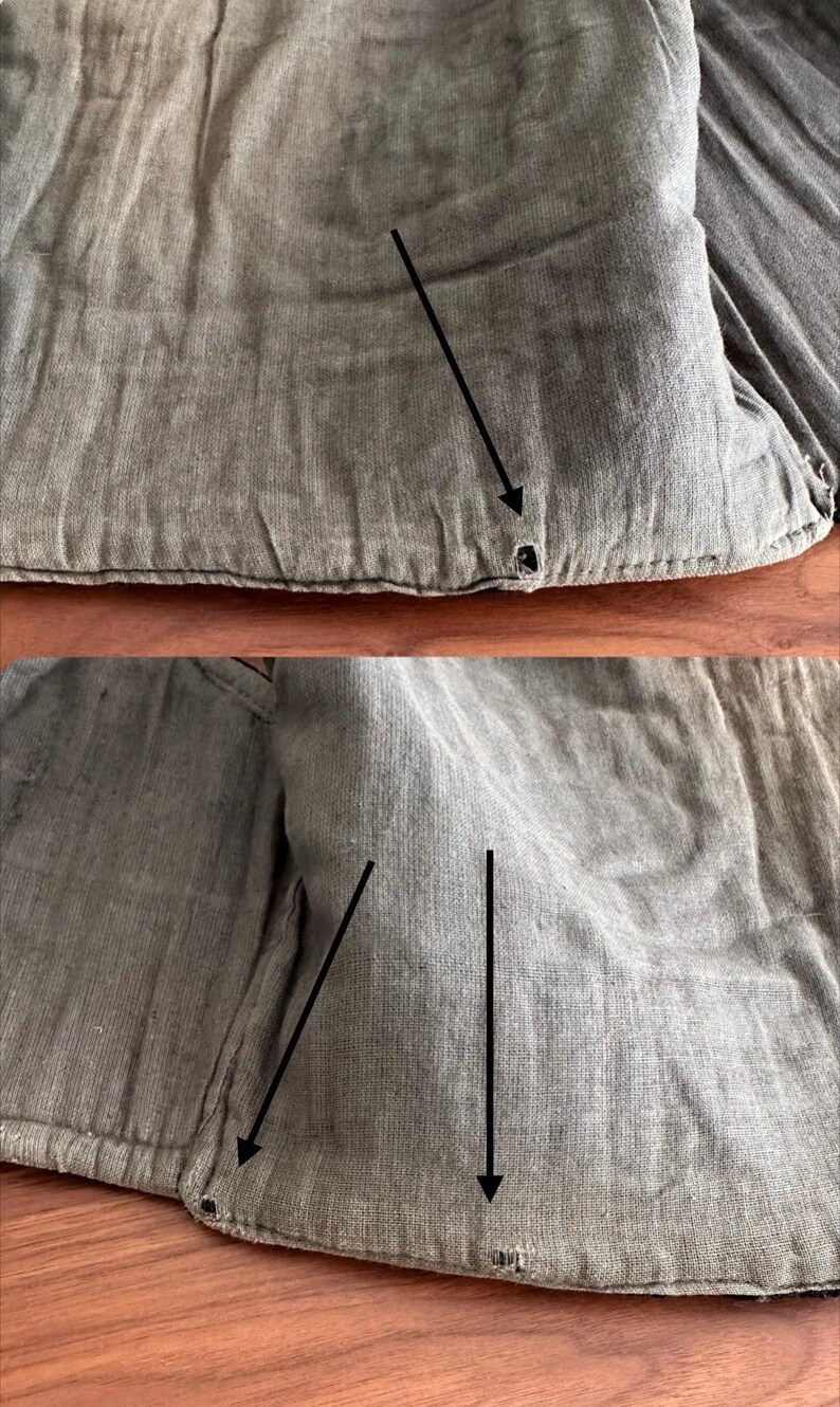 Puede incluir: Una prenda de tela texturizada de color topo con costuras visibles a lo largo de los bordes. El material muestra una apariencia tejida similar al lino con tres peque&ntilde;os agujeros circulares oscuros resaltados por flechas negras que se&ntilde;alan las &aacute;reas.