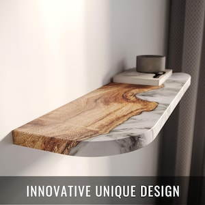 Może przedstawiać: Półka ścienna o unikalnym designie. Półka łączy w sobie wzory słojów drewna i marmuru. Tekst "INNOVATIVE UNIQUE DESIGN" jest wyświetlany na dole obrazu. Na półce znajduje się mały, szary, cylindryczny przedmiot i dwie książki.