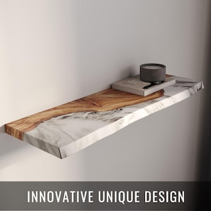 May include: A floating shelf with a unique design, featuring a wood grain and marble effect. A small gray candle and a book rest on the shelf. The text "INNOVATIVE UNIQUE DESIGN" is displayed at the bottom.
