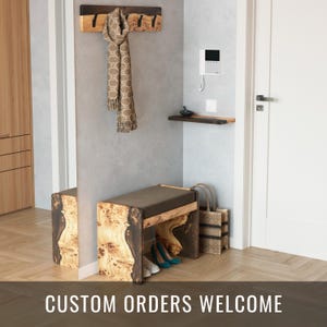Könnte beinhalten: Eine Holzbank mit einem braunen Kissen und einem lebenden Kanten-Design. Die Bank befindet sich in einem Flur mit einem Holz-Kleiderständer und einem Schal, der daran hängt. Der Text "CUSTOM ORDERS WELCOME" befindet sich auf dem Boden.