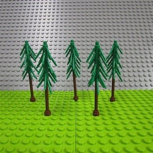 May include: Five green plastic toy pine trees with brown trunks are arranged on a bright green base. The background is a gray surface. The trees are a toy building block set.