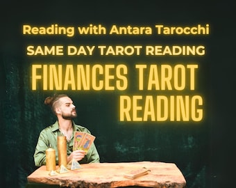 May include: A man with a bun in his hair sits at a wooden table with candles and crystals. He is holding a spread of tarot cards. The text on the wall reads "Reading with Antara Tarocchi", "Same Day Tarot Reading", and "Finances Tarot Reading".