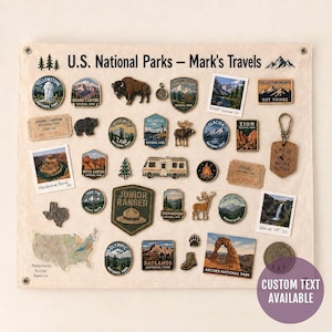 May include: A rectangular canvas wall hanging titled U.S. National Parks - Mark's Travels, featuring a collection of enamel pins, patches, and small photographs depicting various national parks, wildlife, a camper van, and maps.