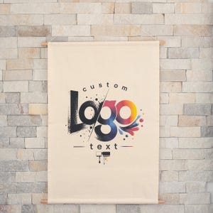 May include: Cream-colored custom logo banner with wooden dowels. The logo features the word "logo" in a stylized font with a black, blue, and rainbow color scheme. The word "custom" is above the logo, and "text" is below.