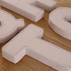 May include: A handmade wooden sign with the text "Welcome" in a playful font. The sign features a distressed white background and a dark brown frame, perfect for a front door or entryway. The sign measures approximately 12 inches wide and 6 inches tall.