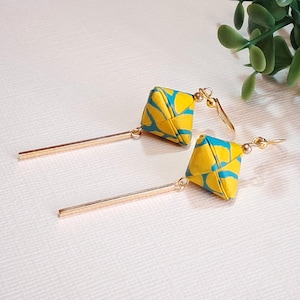 Orecchini di carta origami con ciondoli personalizzati realizzati in carta artigianale a forma di esaedro giallo e blu. Originale regalo di carta per un anniversario.