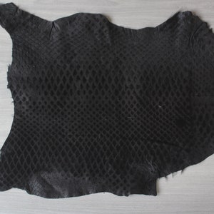 May include: A black snakeskin leather hide with a diamond pattern. The hide is soft and supple, and it has a natural sheen.
