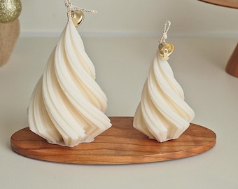 May include: Two white spiral-shaped candles on a wooden base. The candles are topped with small gold bells.