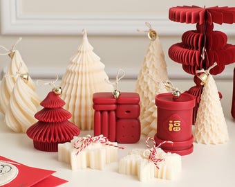May include: Assortment of red and white decorative candles in various shapes, including a tree, a star, and a cylinder. The candles are decorated with gold accents and Chinese characters.