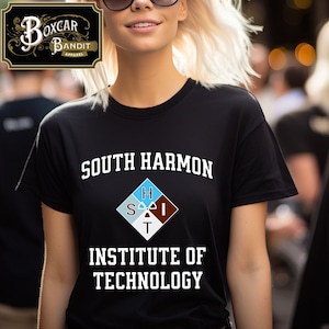 May include: A black t-shirt with white text that reads "South Harmon Institute of Technology". A diamond-shaped logo with the letters "S.H.I.T." is printed below the text.