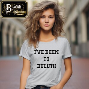 May include: A light gray t-shirt with the text "I'VE BEEN TO DULUTH" in black, displayed in a bold, serif font. The shirt is part of the Boxcar Bandit Apparel collection.