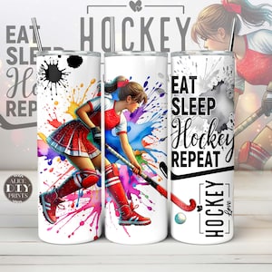 May include: Three stainless steel tumblers with a white background and colorful watercolor splatter design. One tumbler features a female hockey player with a stick and ball. The other two tumblers have the text "Eat Sleep Hockey Repeat" and "Hockey Love".